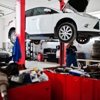 Car repair and maintenance theme. Mechanic in uniform working in auto service.